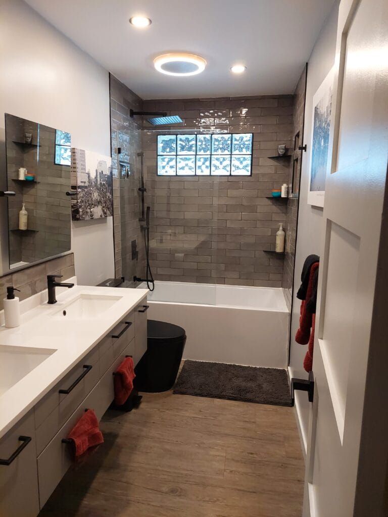 Derek and Sandy's renovated bathroom with a double vanity and tiled soaker tub